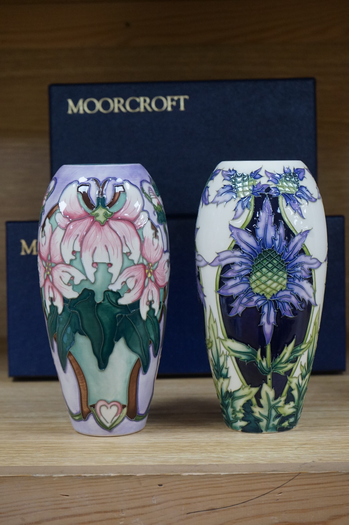 Two Moorcroft vases, Blakeney and a Caledonia patterns, both boxed, 18.5cm